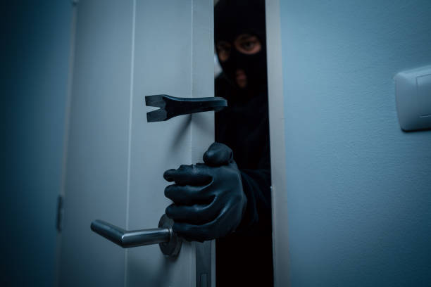 istock Thief in uniform black jacket various action housebreak. The Robber terrorism criminal escapes with balaclava and crowbar entering a house for stealing Housebreak at night 2163996719