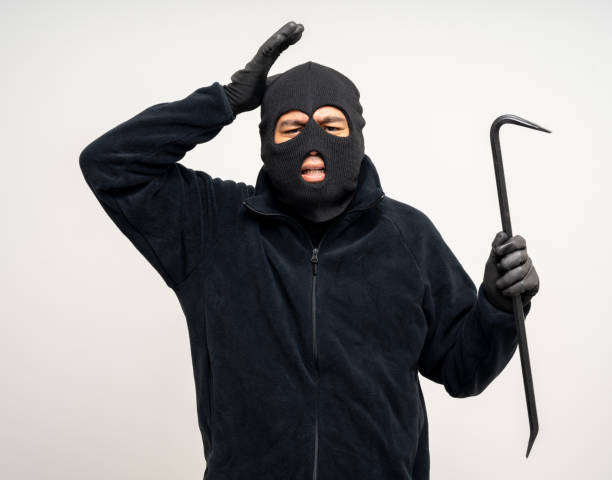 istock Thief in uniform black jacket various pose on isolated background. The Robber terrorism criminal escapes with balaclava and crowbar entering a house for stealing Housebreak 2163996957