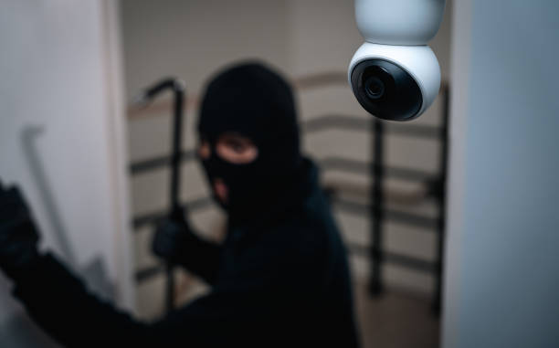 istock Security camera.Thief in uniform black jacket various action housebreak. The Robber terrorism criminal escapes with balaclava and crowbar entering a house for stealing Housebreak at night 2163997132