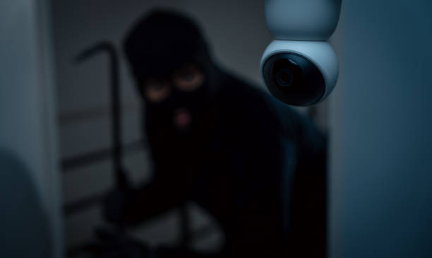 istock Security camera.Thief in uniform black jacket various action housebreak. The Robber terrorism criminal escapes with balaclava and crowbar entering a house for stealing Housebreak at night 2163997301