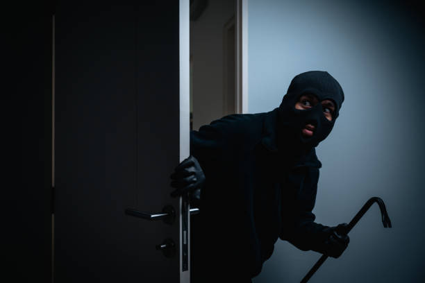 istock Thief in uniform black jacket various action housebreak. The Robber terrorism criminal escapes with balaclava and crowbar entering a house for stealing Housebreak at night 2163997496