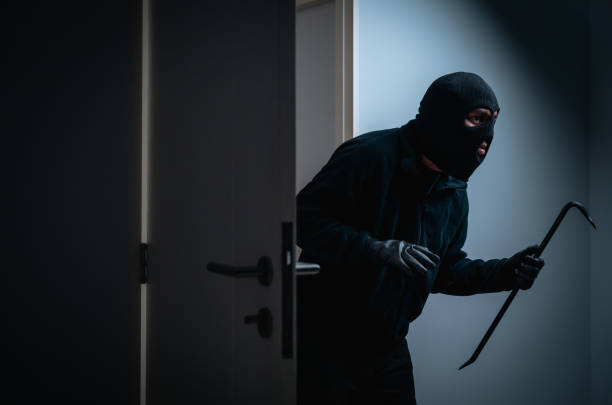 Thief in uniform black jacket various action housebreak. The Robber terrorism criminal escapes with balaclava and crowbar entering a house for stealing Housebreak at night