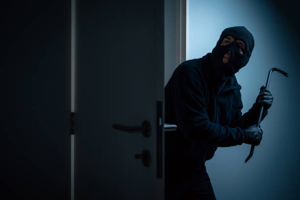 istock Thief in uniform black jacket various action housebreak. The Robber terrorism criminal escapes with balaclava and crowbar entering a house for stealing Housebreak at night 2163998163