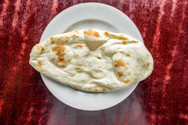 Overhead view of people eating a variety of naan and hummus