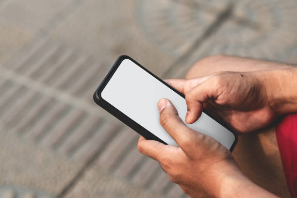 istock Men holding white blank screen smart phone. Typing with two hand on white blank screen phone. Copy space for text 2164001665