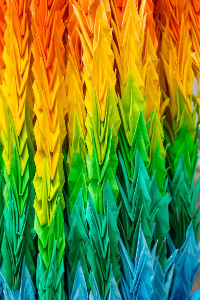 Hundreds of multi colored peace crane origami hanging close up.