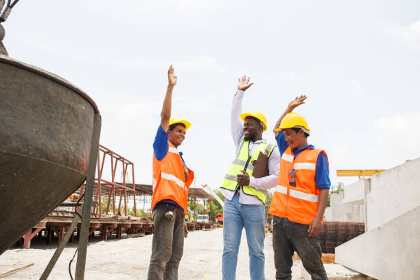 istock Team of construction workers touch their hands together. 2164004680