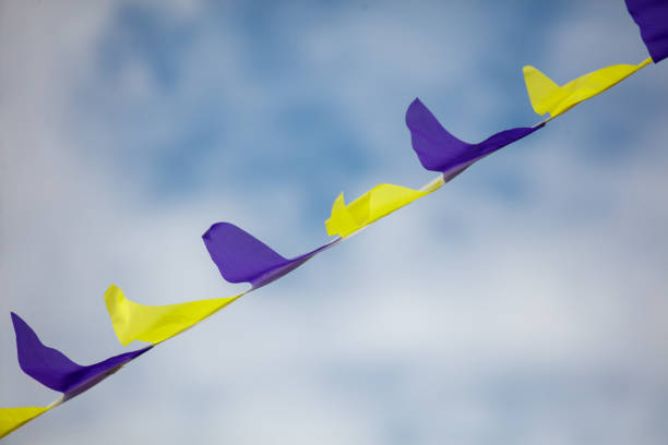 Festive blue yellow flags against the sky.