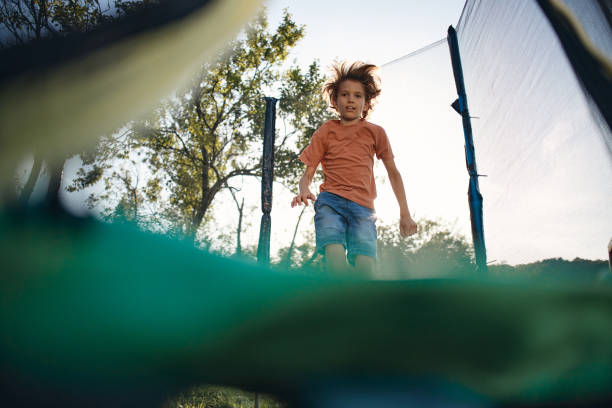 Beautiful boy enjoying summer days on trampoline.