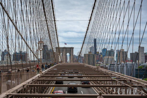 Close-up of a bridge pier and its ropes. You can see the Brooklyn Bridge. Network and symmetry of Brooklyn Bridge suspension cables. High quality photo
