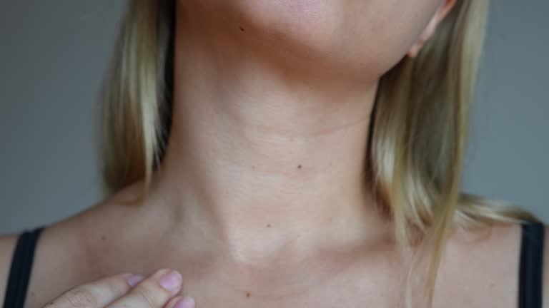 Young blonde woman touching her neck with her hands. Lines on the female neck. Wrinkles, age-related changes, rings of Venus, creases, goosebumps