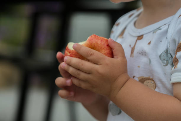 istock Toddler holding an apple (close-up) 2164011477