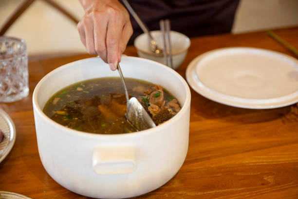 A person is cooking soup in the kitchen