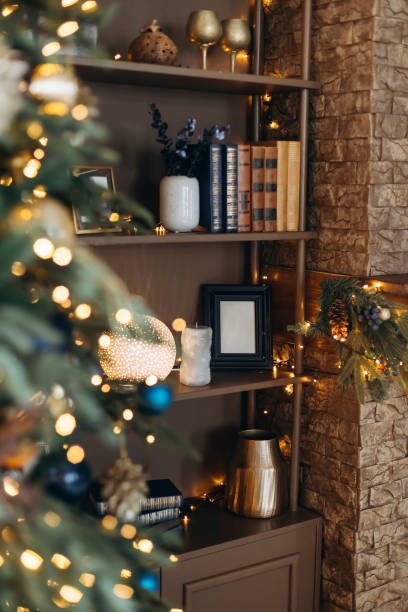 istock Bookcase with books and Christmas decorations through bokeh from Christmas tree lights. Christmas decorations 2164013979