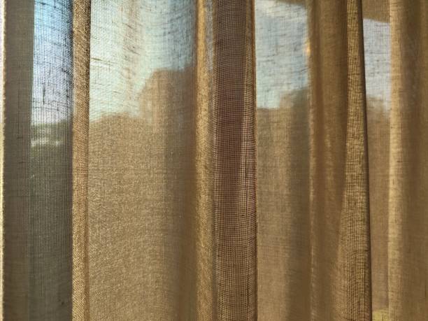 istock Golden curtains with blue sky and buildings behind 2164022045