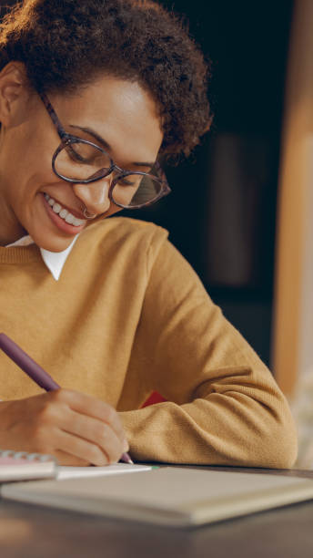 istock Smiling female manager working remotely on laptop from home and making notes 2164026451