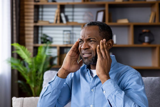 istock Stressed man experiencing headache sitting at home in casual attire 2164031310