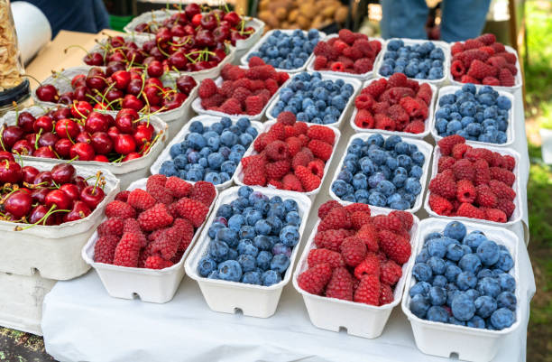 istock Various baskets filled with fresh cherries, raspberries, and blueberries at a market stall, vibrant colors 2164032927