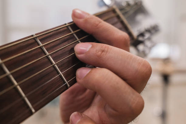 Teenage girl practicing her guitar skills at home