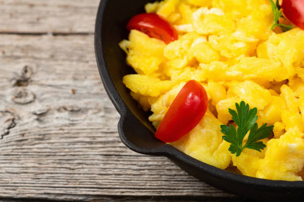istock Healthy vegetarian breakfast . Scrambled eggs in pan with cherry tomatoes and parsley 2164034657