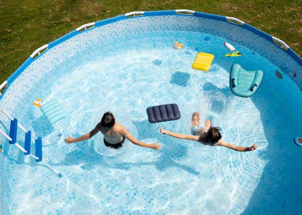 istock Boys  jumping in the swimming pool.  High angle view. 2164035168
