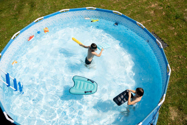 istock Boys  jumping in the swimming pool.  High angle view. 2164035174