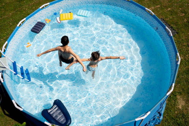 istock Boys  jumping in the swimming pool.  High angle view. 2164035176