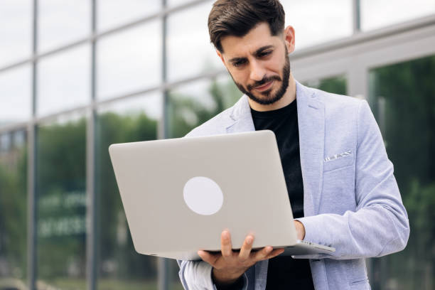istock Caucasian handsome man trader working at laptop checking stock market data, looking at computer. Male successful broker with smile. Businessman 2164041526