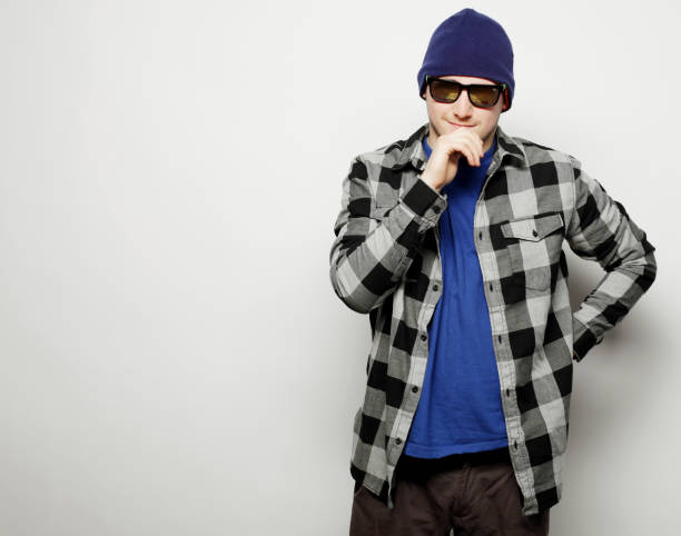Stylish young man with a baseball cap in a gray t-shirt posing in the studio.