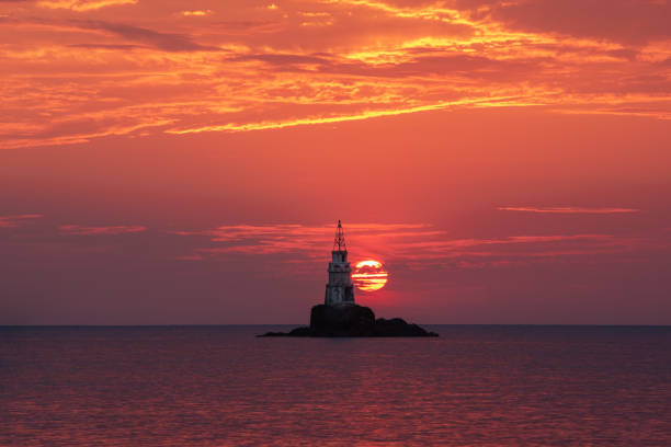Lighthouse against the backdrop of a dramatic sunset  sunrise. Ahtopol, Bulgaria