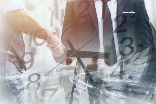 istock Business time fast moving speed working hours concept. Business people dealing project hand shaking overlay clock face. 2164054475