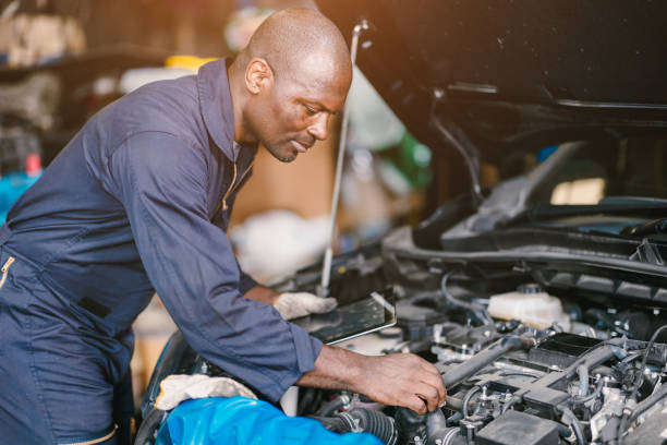 istock African Black man Car Service focus at work. Mechanic working in garage workshop maintenance engine. 2164057123