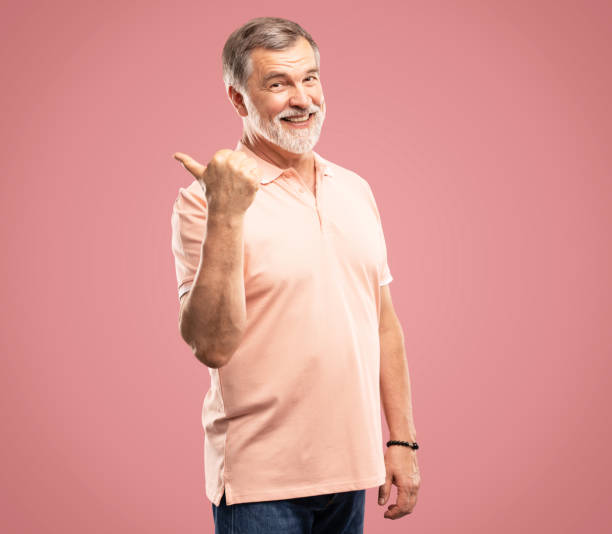 istock Handsome mature man standing showing thumbs up isolated on pink background 2164060892