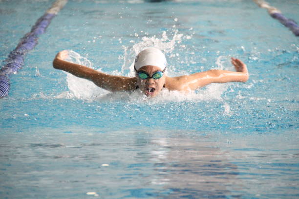 Rear View Of Woman Swimming In Pool