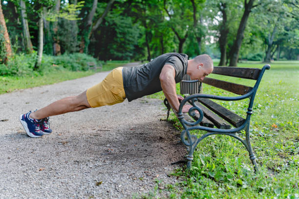 istock Young man performing muscle stretching exercises on park bench after strenuous run in sunny afternoon 2164065068