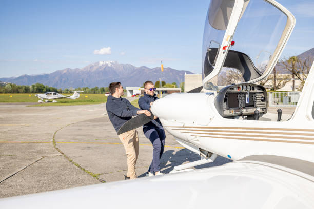 istock Pilots Maneuvering Light Aircraft on Tarmac 2164065122