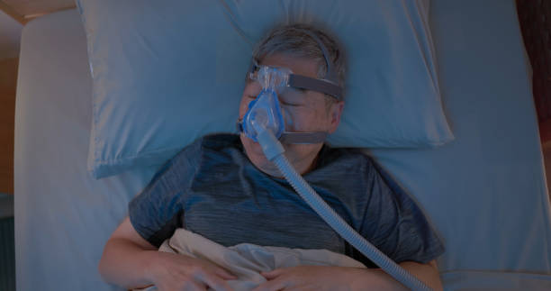 istock old man sleep with CPAP 2164069279