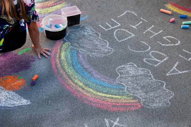 istock Children draw a rainbow on the asphalt with colored chalk. Sidewalk. 2164072528