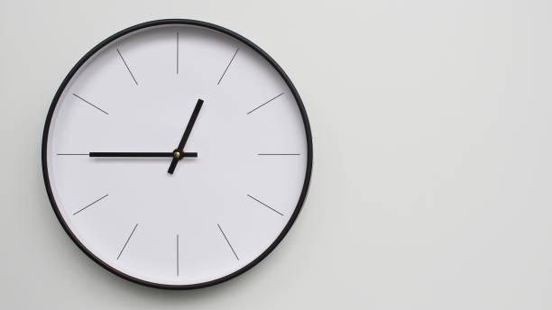 istock Wall Clock Showing 00.45 O'Clock on White Wooden Surface - Perfect for Time Management and Scheduling Concepts 2164077257