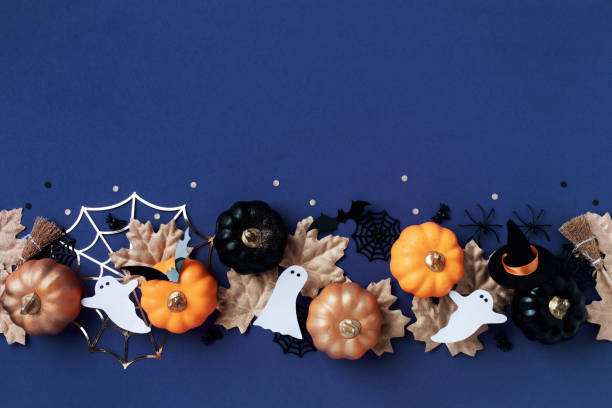 istock Halloween party decorations from pumpkins, bats, spider web, ghosts on dark blue background top view. Happy halloween holiday greeting card template. 2164080637