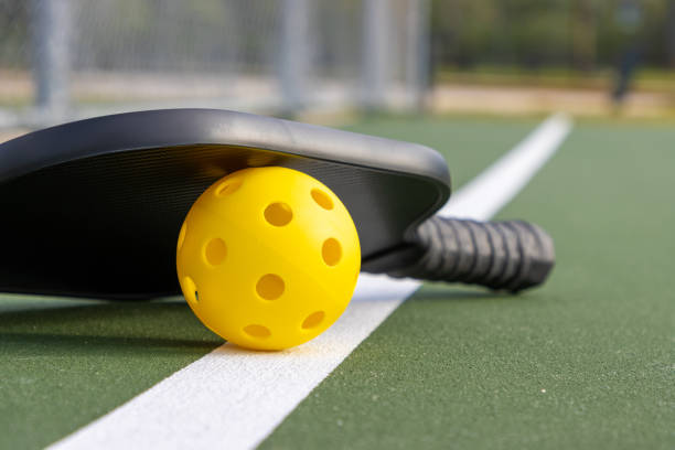istock Pickleball paddle and ball on court 2164081936