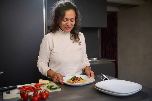 istock Woman preparing a delicious pasta dish in modern kitchen with fresh tomatoes and basil 2164090800