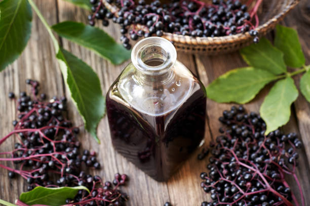 istock A bottle of black elder syrup with fresh elderberries on a wooden table 2164101822