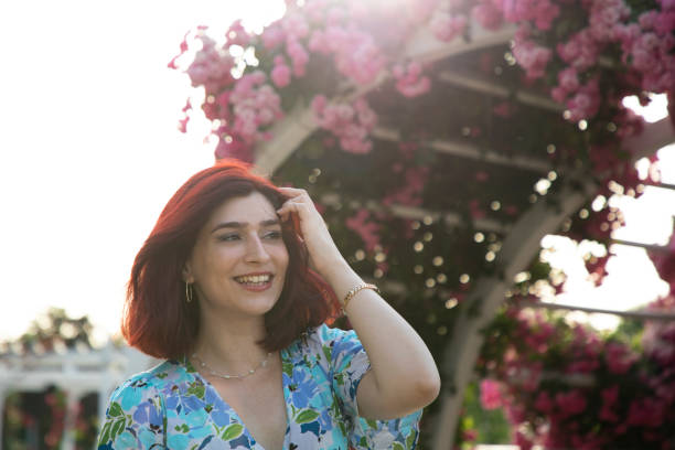 Young redhead woman smiles under the sun