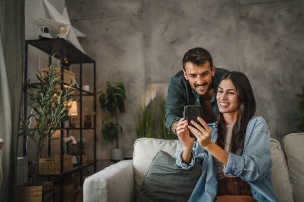 istock Wife show on cellphone to husband how work cctv surveillance camera 2164104893
