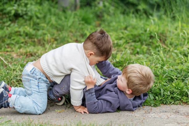 istock Children in Playful Fray on Grass. 2164104903