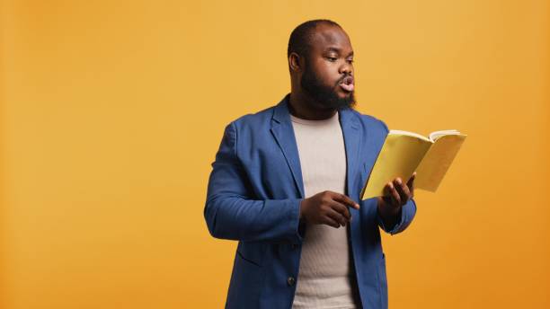 istock Man reading book aloud, narrating story for audience, studio background 2164106999
