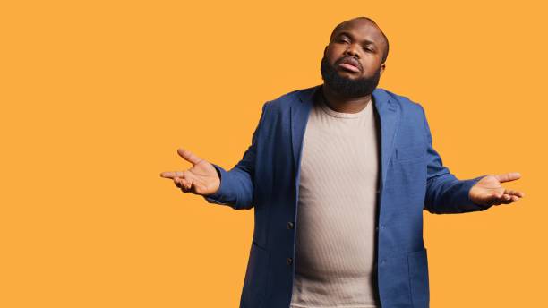 istock Man shrugging shoulders, not caring, studio background 2164107219