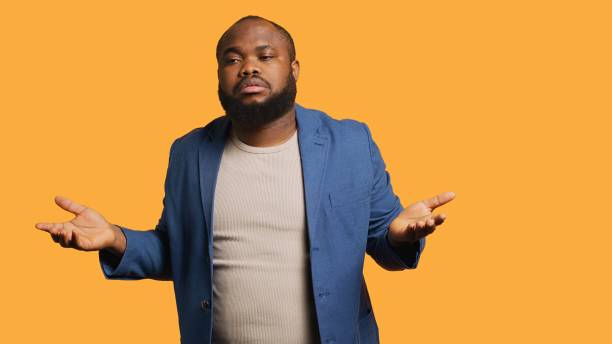 istock Man shrugging shoulders, not caring, studio background 2164108311