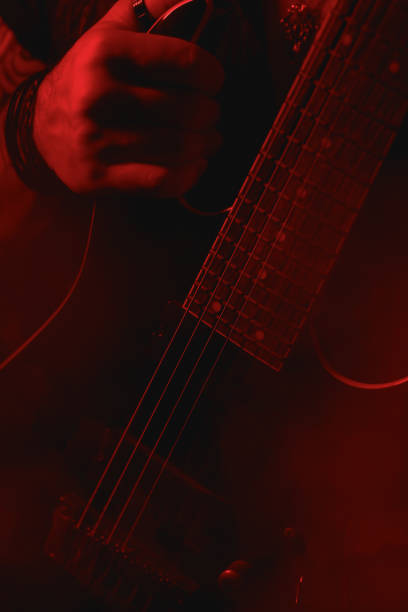 istock Close-up of Hand Holding a guitar under red Light 2164110194